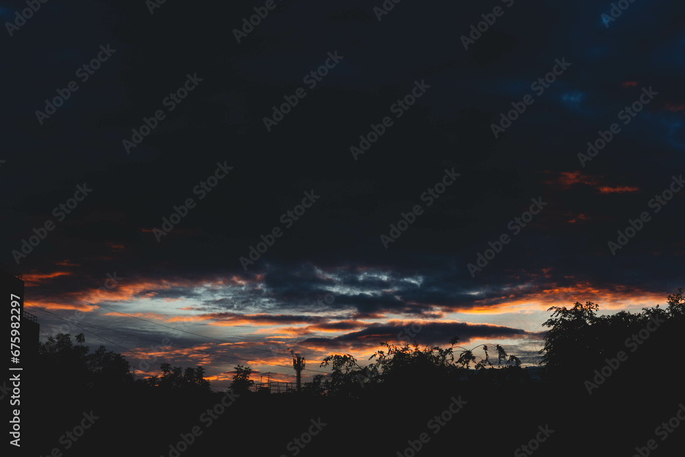 Beautiful sunset sky in dark shades. The sunset breaks through the black clouds.