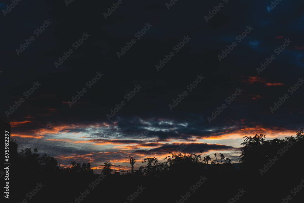 Beautiful sunset sky in dark shades. The sunset breaks through the black clouds. Beautiful sunset sky in dark shades. The sunset breaks through the black clouds.