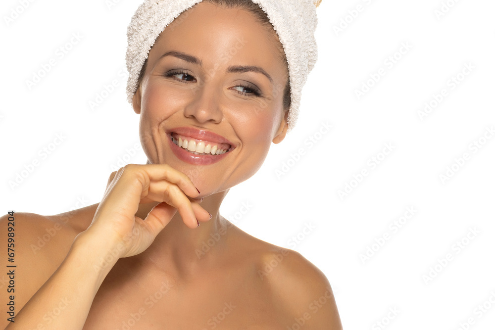 Beauty portrait of a cheerful attractive half naked woman with a towel wrapped around her head with toothy smile and looking at camera isolated over white studio background. Beauty portrait of a cheerful attractive half naked woman with a towel wrapped around her head with toothy smile and looking at camera isolated over white studio background.
