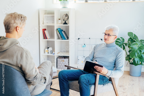 Professional psychotherapy. Male psychologist having session with male patient at mental health clinic, Taking Notes During Appointment In Office. Psychological help service. Treatment of depression