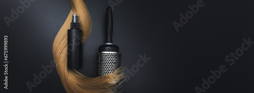 Blond shiny hair wave, Round brush for styling hair and Hair care spray, on black background. Hairdresser service, hair strength, haircut, hairstyle. Concept hairdresser spa salon. photo