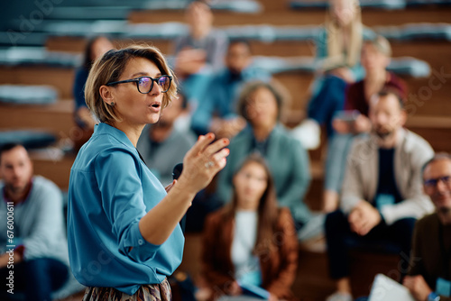Tableau sur toile Female speaker giving presentation during business seminar at convention center
