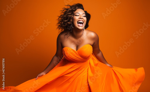Happy smiling, laughing young plus size curvy busty, women in elegant orange wedding dress having fun on isolated plane background