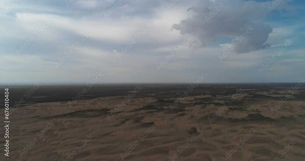 Dronn flies over the sand dunes of the desert on a cloudy day Dronn flies over the sand dunes of the desert on a cloudy day