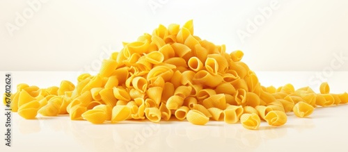 In the background of the isolated white kitchen the texture of the cooking wheat pasta added a nutritious element to the shape of the yellow dinner meal making it a delectable cuisine and a
