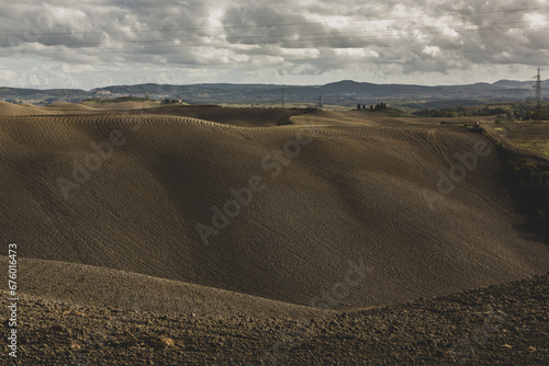 Harvested Fields and meadows landscape in Tuscany  Italy. Wavy country scenery at autumn sunset. Arable land ready for the agricultural season.