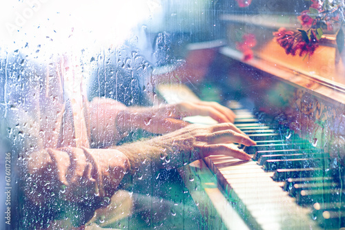 Concepto de música de piano fondo abstracto.
Tocando canción de piano detrás de la ventana con gotas de agua en un día lluvioso. Música triste para el viaje. photo