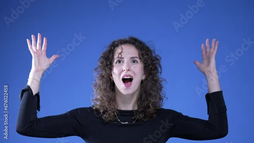 Funny Woman Mimicking Head Explosion on Blue Background, Shocked Yet Amused having a breakthrough idea, feeling enlightened