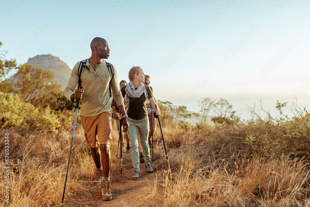 © Marko Geber - Group of young hikers looking at sunset on mountain