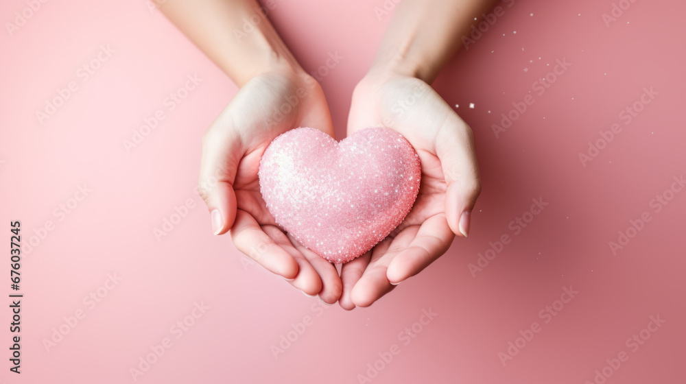 Female hands gently holding the heart. Pink background. Female hands gently holding the heart. Pink background.