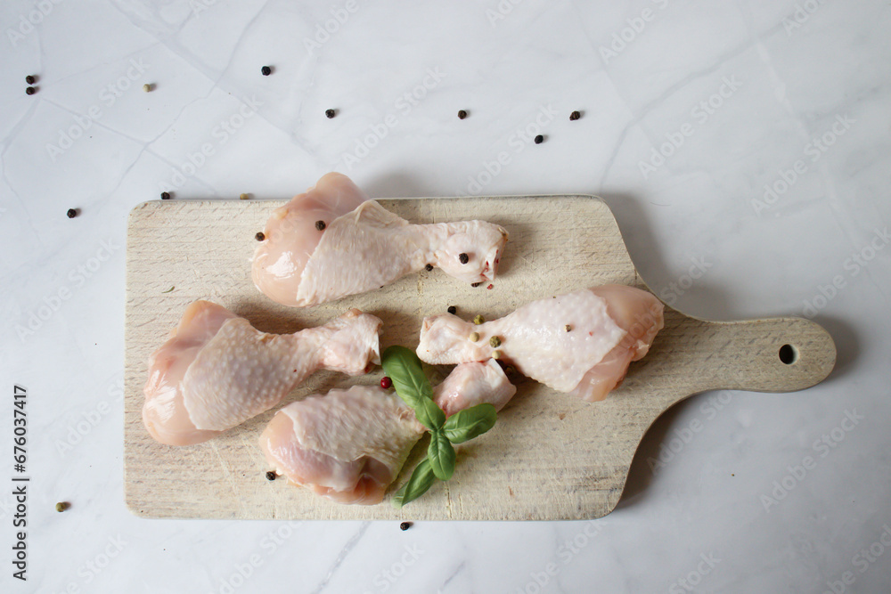 Fototapeta premium Raw chicken legs with spices and herbs. on a white background. food