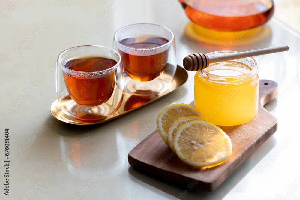 Healing warm tea with honey and lemon at home table Healing warm tea with honey and lemon at home table