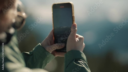 Female hiker takes photos of the beautiful snowy Colorado mountain range