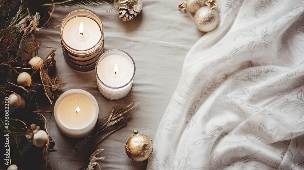 Φωτογραφία a couple of candles sitting on top of a bed next to a christmas ornament and a pine cone