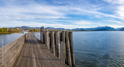 View of the wooden bridge crossing the upper Zurich Lake (Obersee) along the old way of St. James, Rapperswil, St. Gallen, Switzerland photo