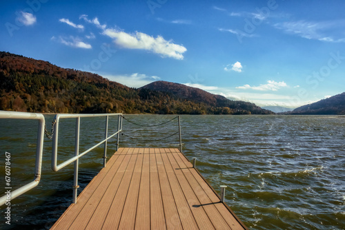 Pier on the lake over Klimkowka in the Low Beskids, in Poland on a sunny autumn day