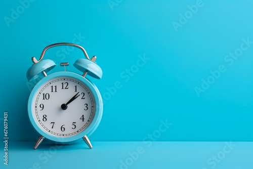 White alarm clock on blue background with copy space for text. Time concept