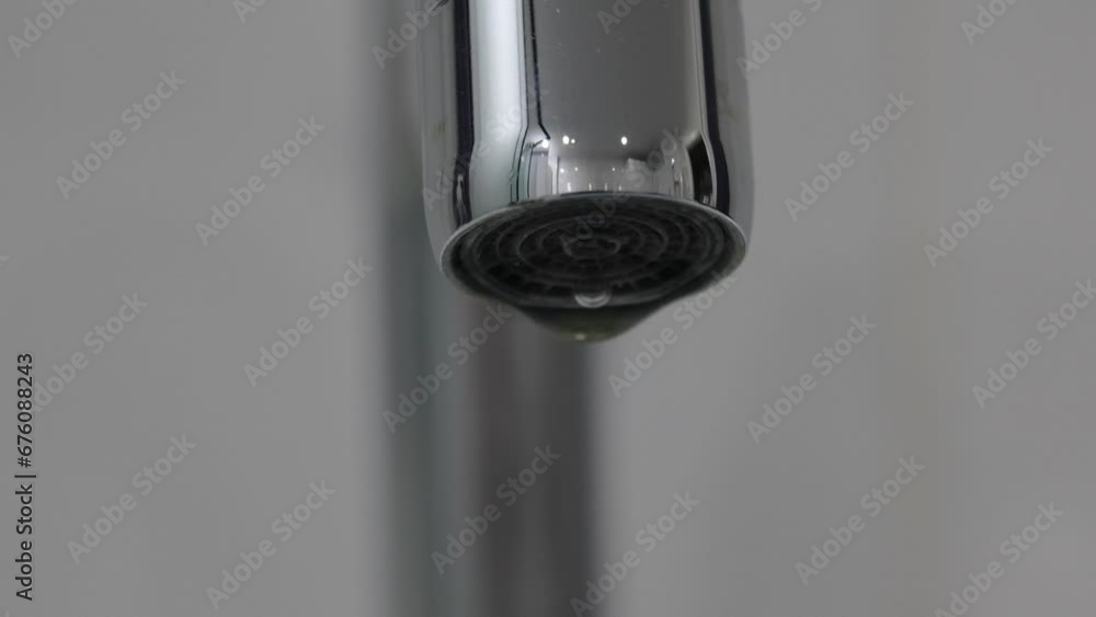 Extreme close-up of a metal water faucet on a white background isolated. Extreme close-up of a metal water faucet on a white background isolated.