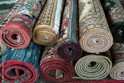 Rugs, different Persian style stacked roll rugs, many rolls of assorted rugs