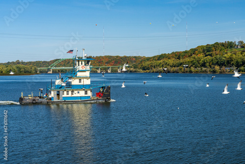 Pusher tug boat sails on Mississippi river between Dubuque Iowa and Illinois in the fall