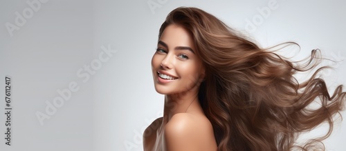 The beautiful woman with flawless hair is captured in a happy portrait her face glowing against the white background while showcasing her natural beauty and healthy lifestyle Her makeup enha photo