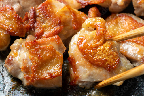地鶏もも肉をフライパンでこんがり焼く調理シーン。 