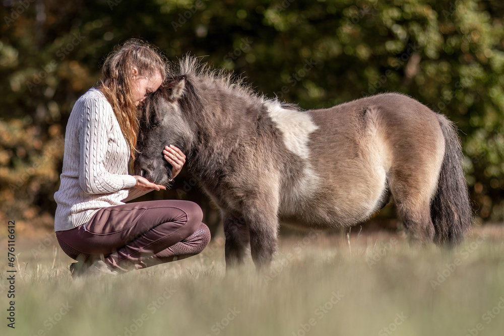 Natural Horsemanship concept: Cute portrait of a young woman and her pony working and interacting together Natural Horsemanship concept: Cute portrait of a young woman and her pony working and interacting together