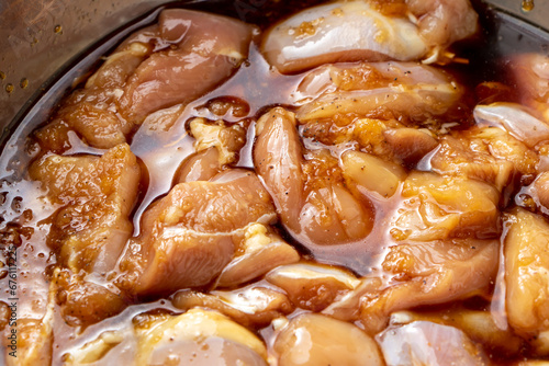 鶏肉の唐揚げ調理シーン。鶏もも肉に下味をつけるため、タレに漬け込む。
 photo