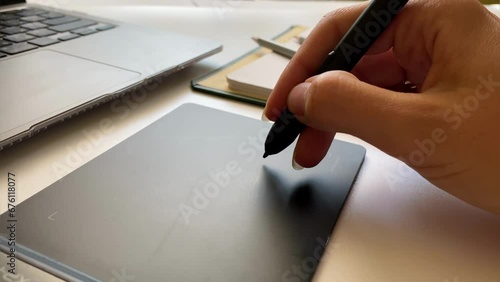 Close-up of a hand working with a pencil for a graphics tablet photo