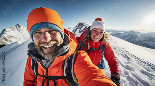Portrait of a happy couple at the peak of a snow covered mountain.Achievement, hiking, snowboarding, skiing concept. 