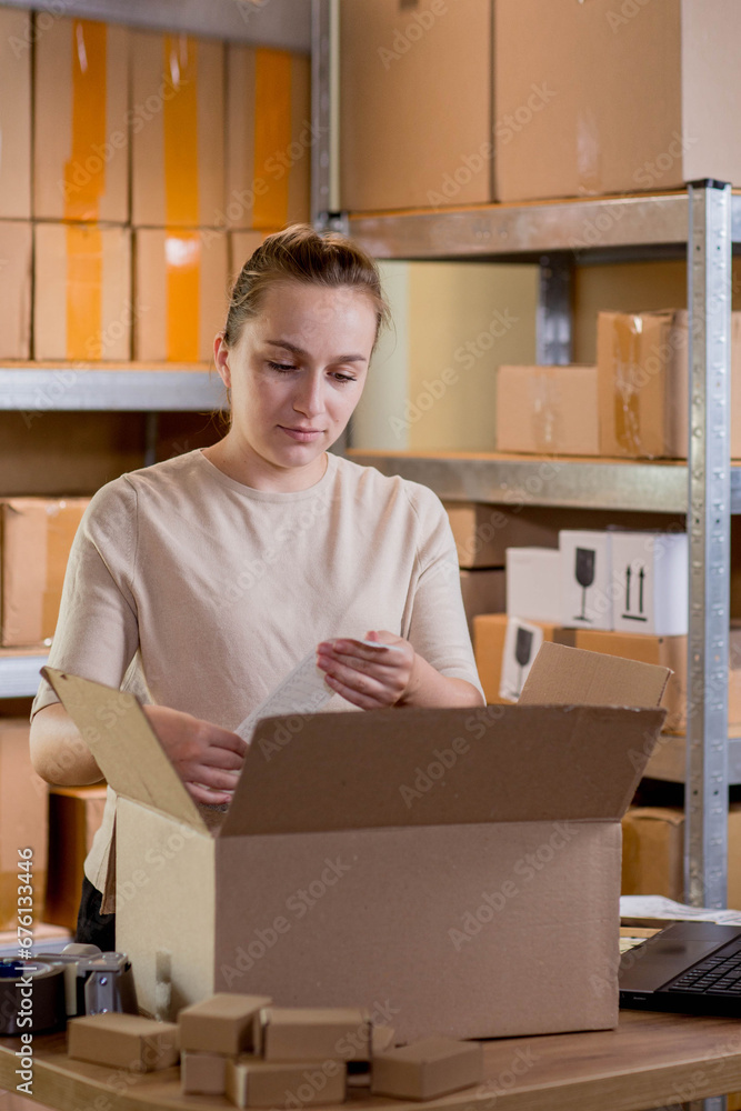 Smiling female entrepreneur packing parcel using tape dispenser. Woman preparing the product box for delivery to customer. Online business, ecommerce and delivery concept Smiling female entrepreneur packing parcel using tape dispenser. Woman preparing the product box for delivery to customer. Online business, ecommerce and delivery concept