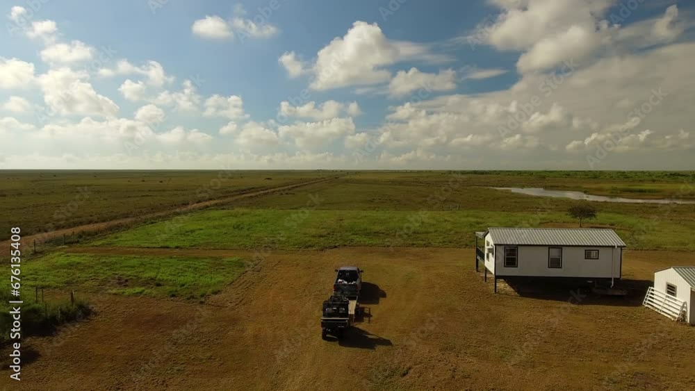 Aerial Panning Shot Of Vehicles Near Houses Amidst Farm Against Cloudy Sky - Bayou, Louisiana Aerial Panning Shot Of Vehicles Near Houses Amidst Farm Against Cloudy Sky - Bayou, Louisiana