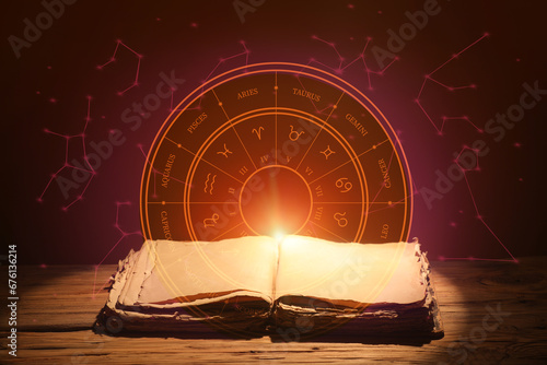 Open old astrology book on table against dark background photo