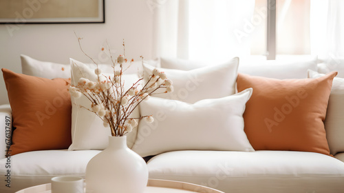 Close up of fabric sofa with white and terra cotta pillows. French country home interior design of modern living room. photo