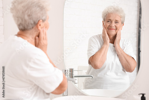 Εκτύπωση καμβά Senior woman looking in mirror at home