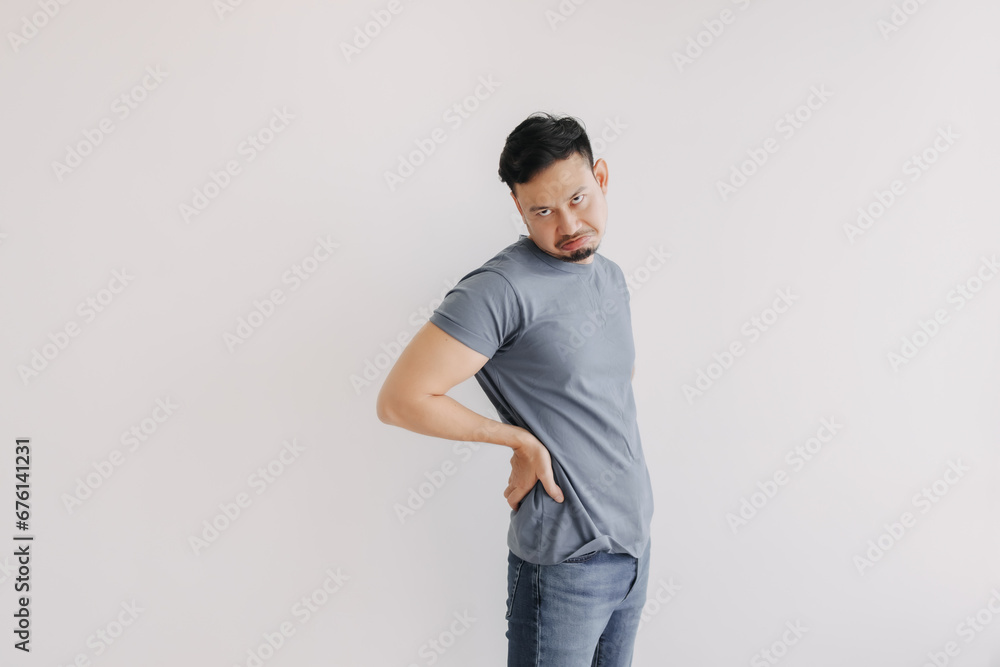 Disappointed and bored face of asian man in blue t-shirt stand isolated on white wall.