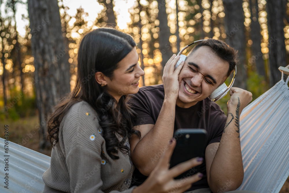Man and woman young adult couple in nature listen music headphones Man and woman young adult couple in nature listen music headphones