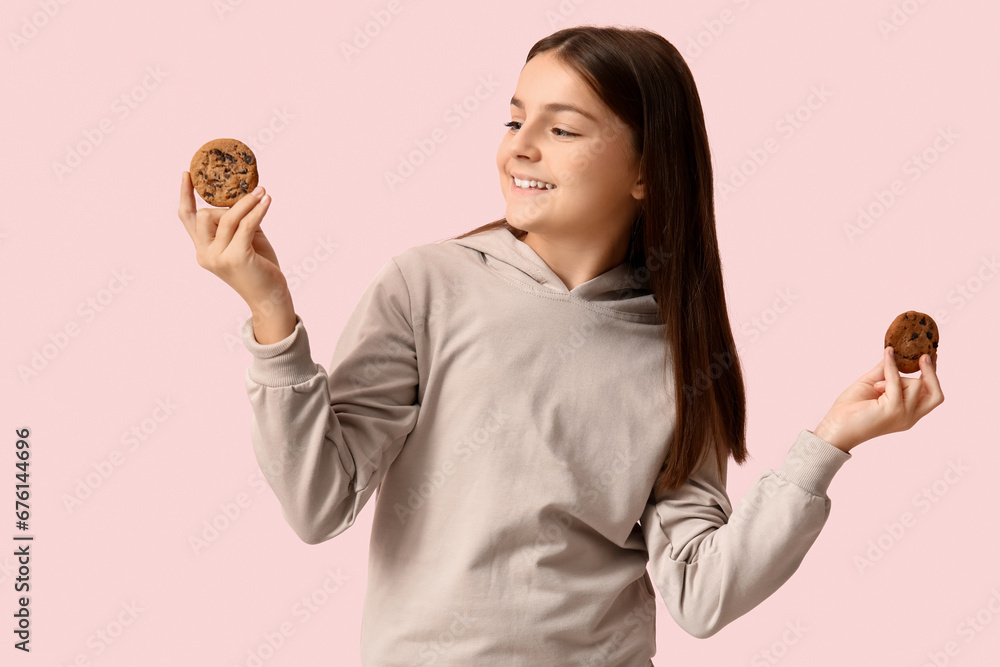 Little girl holding sweet chocolate cookies on pink background Little girl holding sweet chocolate cookies on pink background