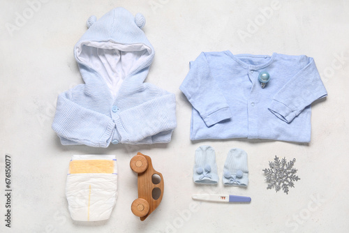 Composition with baby clothes, accessories, pregnancy test and Christmas decor on light background