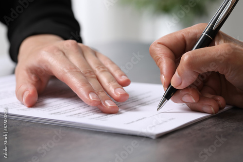 Manager showing client where she must to mark signature at dark table indoors, closeup photo