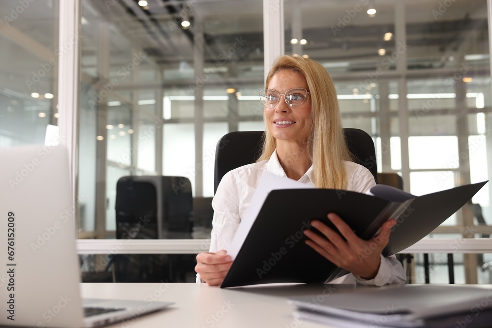 Smiling woman working at table in office. Lawyer, businesswoman, accountant or manager Smiling woman working at table in office. Lawyer, businesswoman, accountant or manager