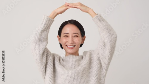 腕で丸印のジェスチャーをする中年女性　白背景