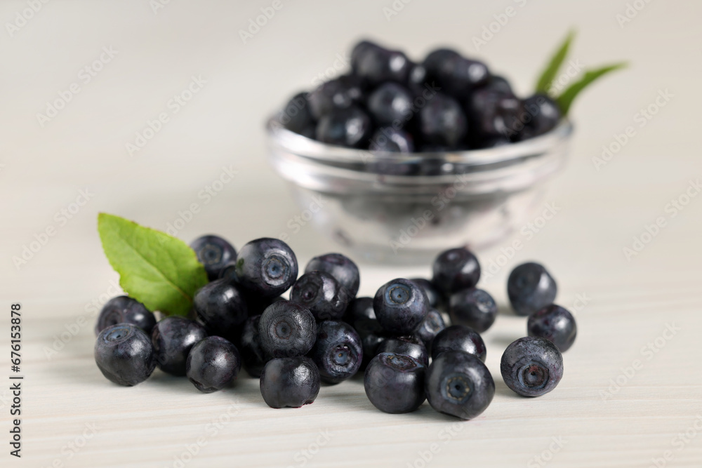 Ripe bilberries and leaves on white wooden table, closeup Ripe bilberries and leaves on white wooden table, closeup