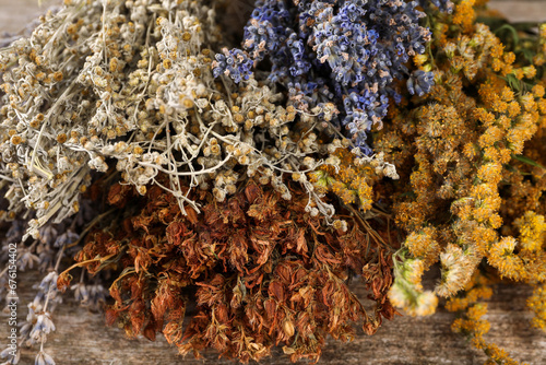 Foto Many different dry herbs on wooden table, closeup