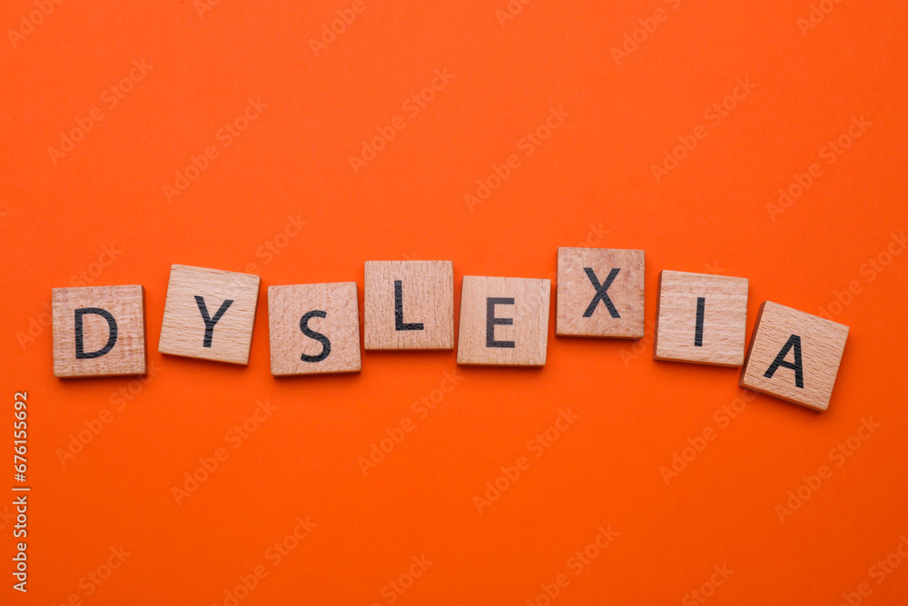 Obraz premium Wooden cubes with word Dyslexia on orange background, flat lay