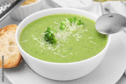 Delicious broccoli cream soup with cheese on white table, closeup