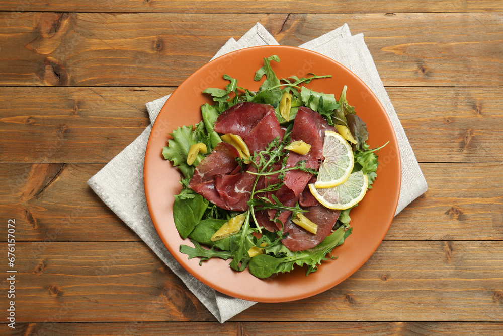 Delicious bresaola salad on wooden table, top view Delicious bresaola salad on wooden table, top view