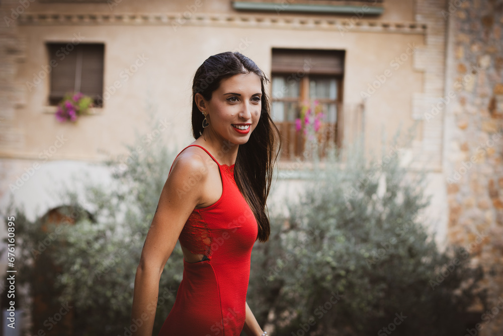 Mujer con vestido rojo, posa para retrato en un bonito pueblo de España. 50 mm