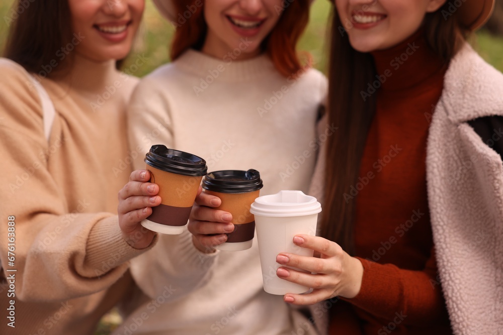 Happy three friends with cups of coffee outdoors, closeup Happy three friends with cups of coffee outdoors, closeup