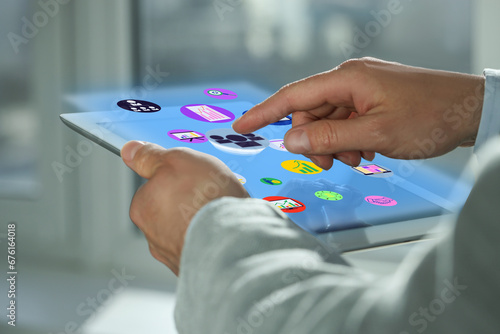 Marketing strategy. Man using tablet computer with virtual screen and icons indoors, closeup
